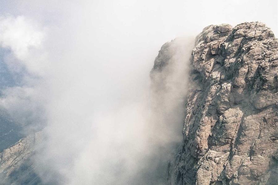 A rock face emerging from low cloud